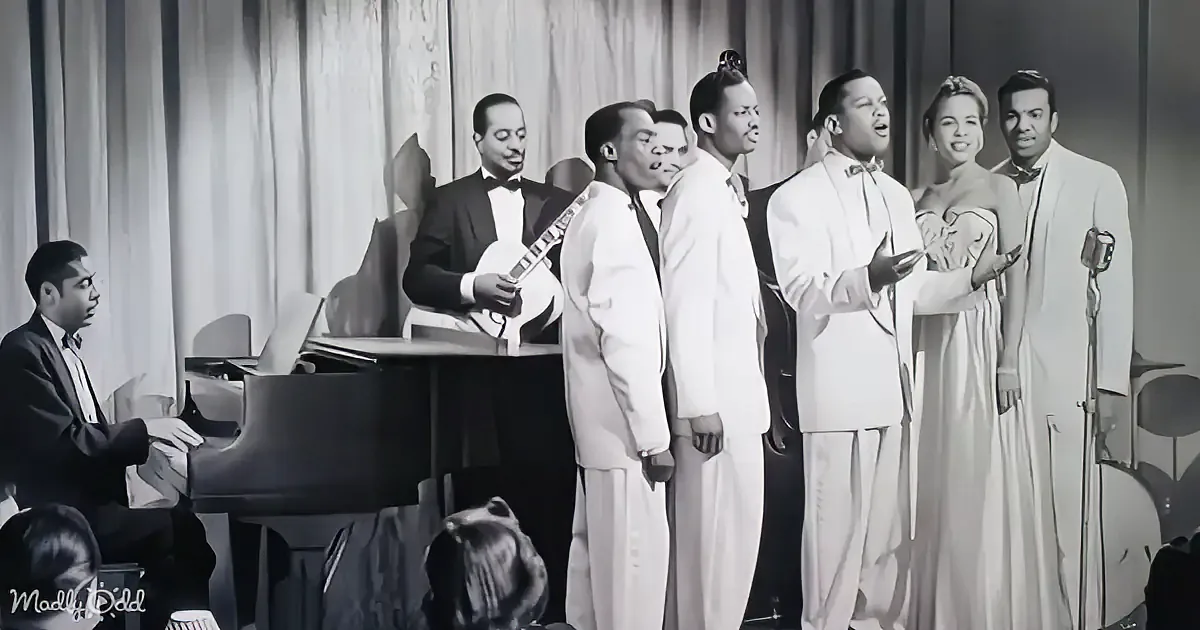 A group of musicians in formal attire performs on stage with a pianist and a banjo player.