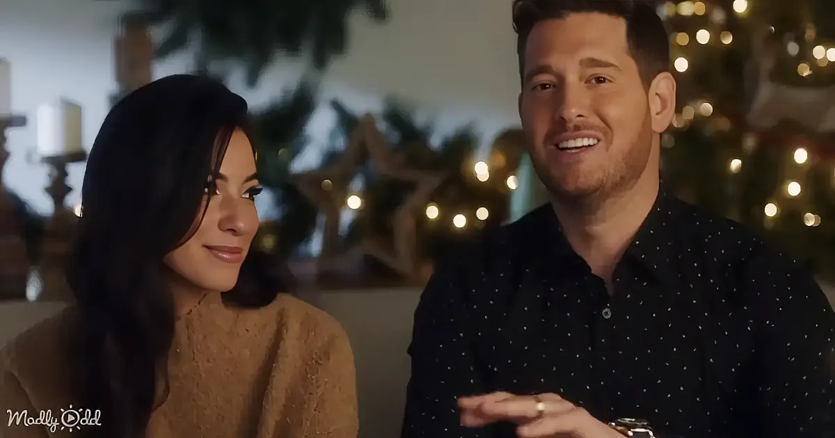 A man in a polka-dot shirt smiles while sitting next to a woman with long dark hair, both in a festive setting with...