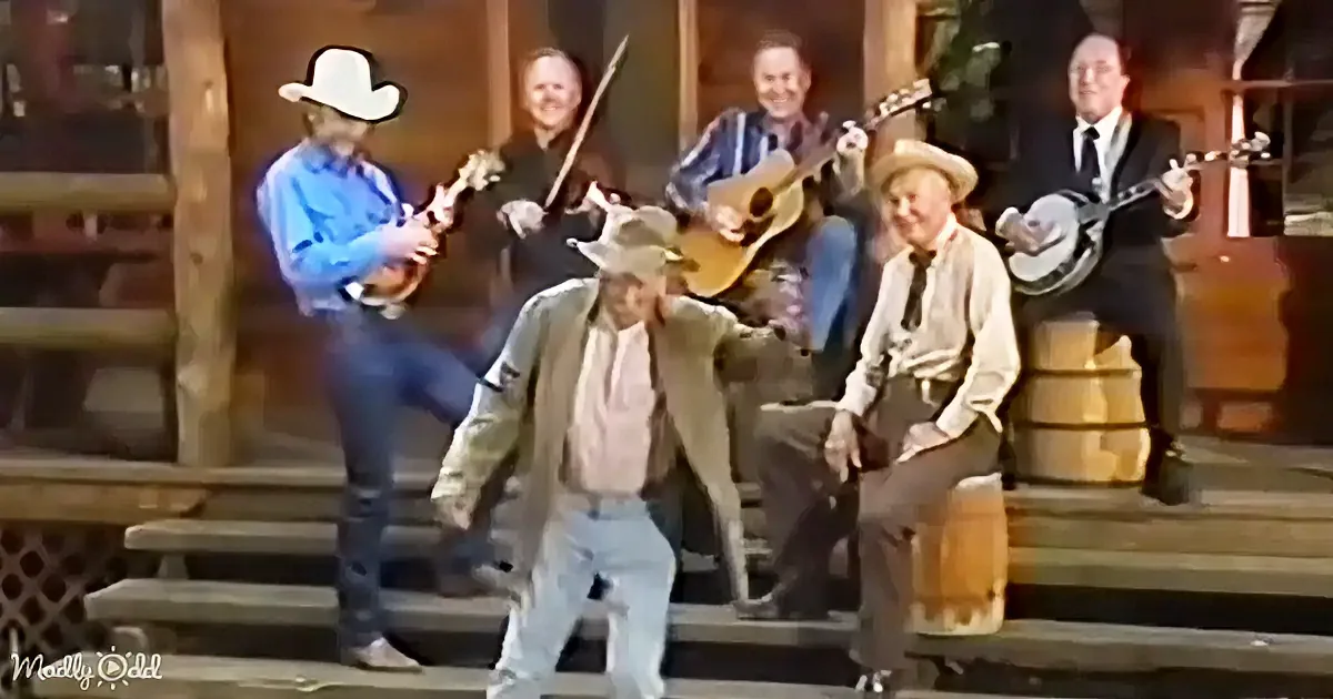 A group of musicians in cowboy attire play instruments on a rustic porch.