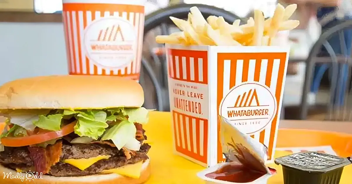 A Whataburger meal featuring a burger with lettuce and tomato, and two boxes of fries.