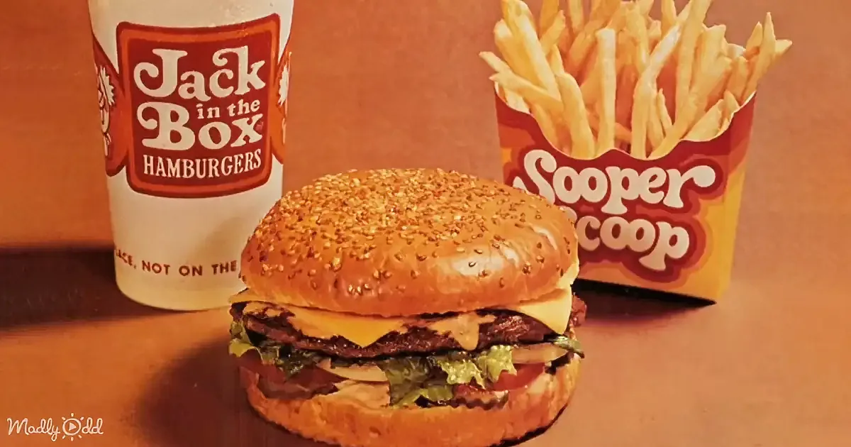 A double cheeseburger with lettuce and tomato, Jack in the Box drink, and super scoop fries are displayed.