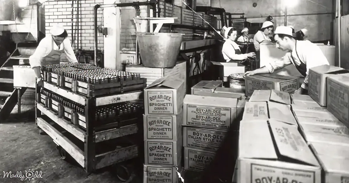 Workers in a factory pack Boy-AR-Dee spaghetti dinner boxes.