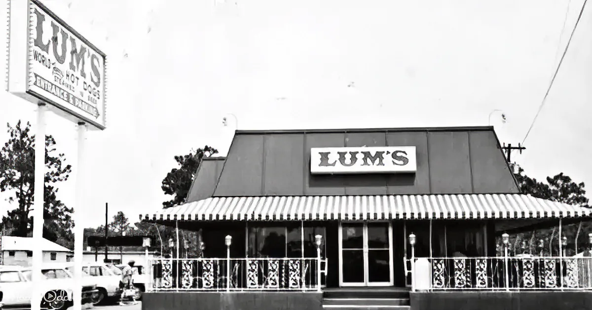 Lum's restaurant with sign, striped awning, and decorative railing in front.