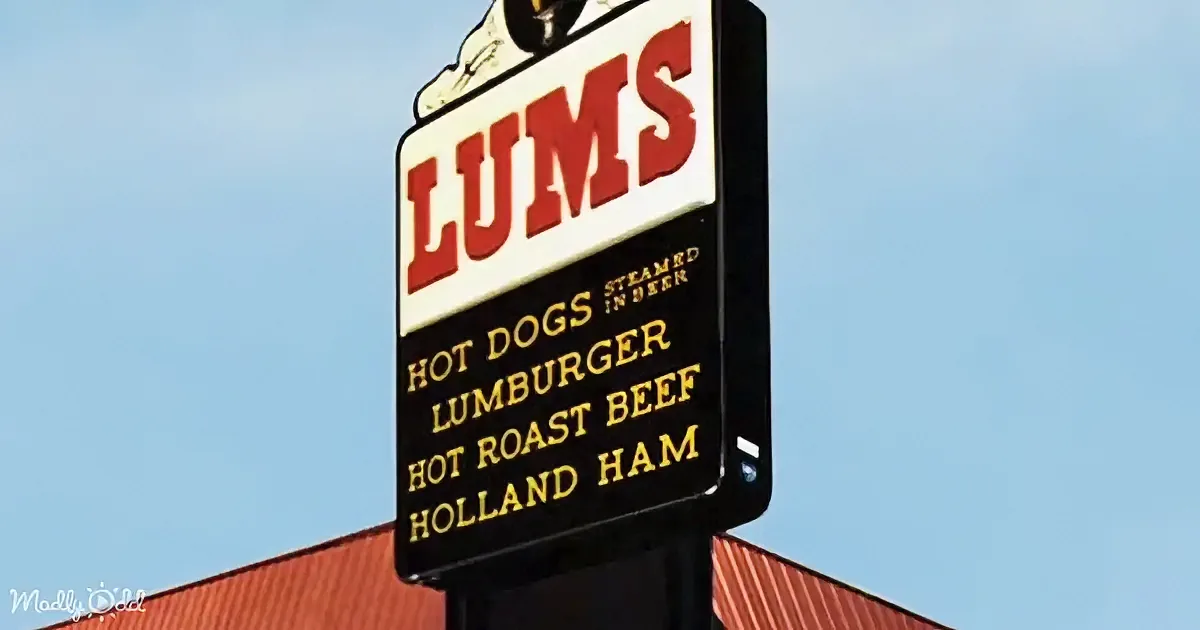 A sign for "LUMS" advertises hot dogs, Lumburger, hot roast beef, and Holland ham.