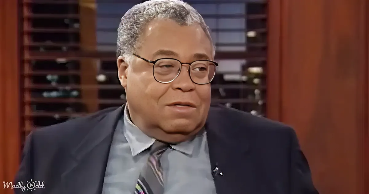 A man in a suit and tie, wearing glasses, appears to be speaking or listening intently.