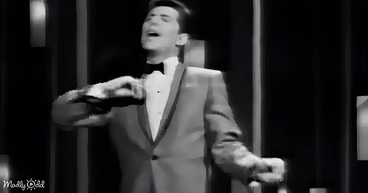 A man in a suit and bow tie is singing passionately, holding a microphone.