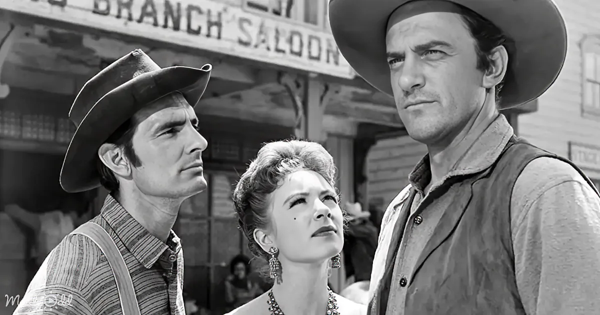 Three individuals in cowboy attire stand in front of a saloon, looking upward with expressions of concern or curiosity.