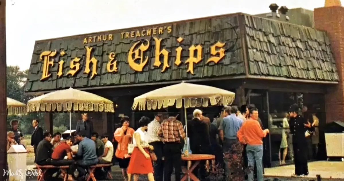 Arthur Treacher's Fish & Chips restaurant with people eating and standing outside under umbrellas.