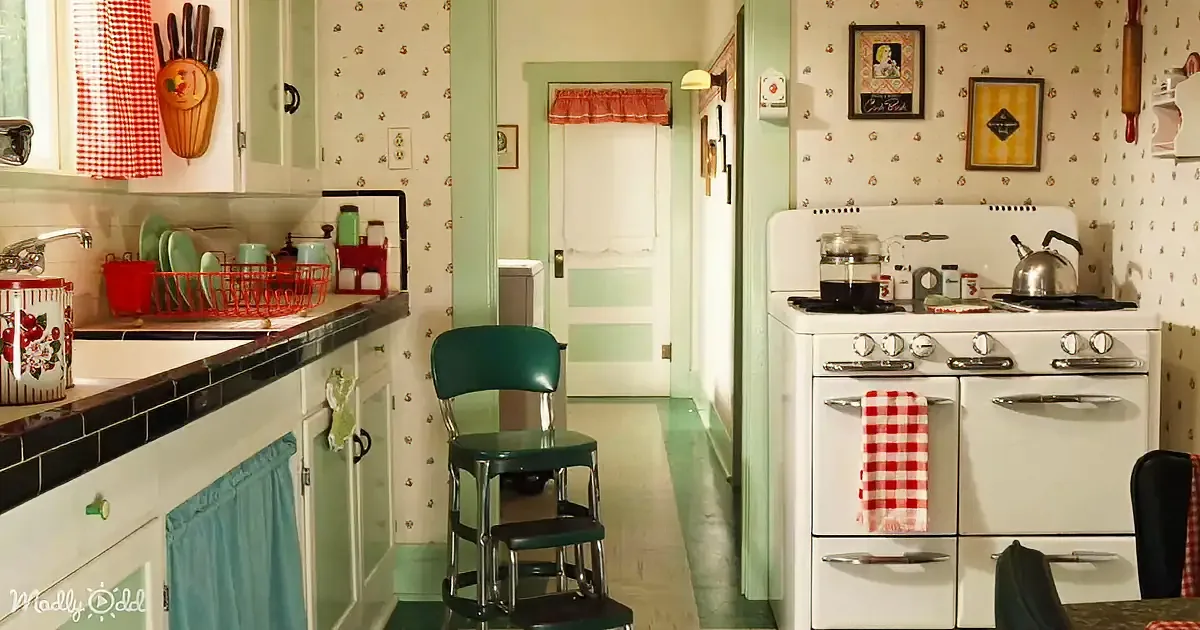 A retro kitchen with a white stove, green chair, red checkered towel, and vintage decor.