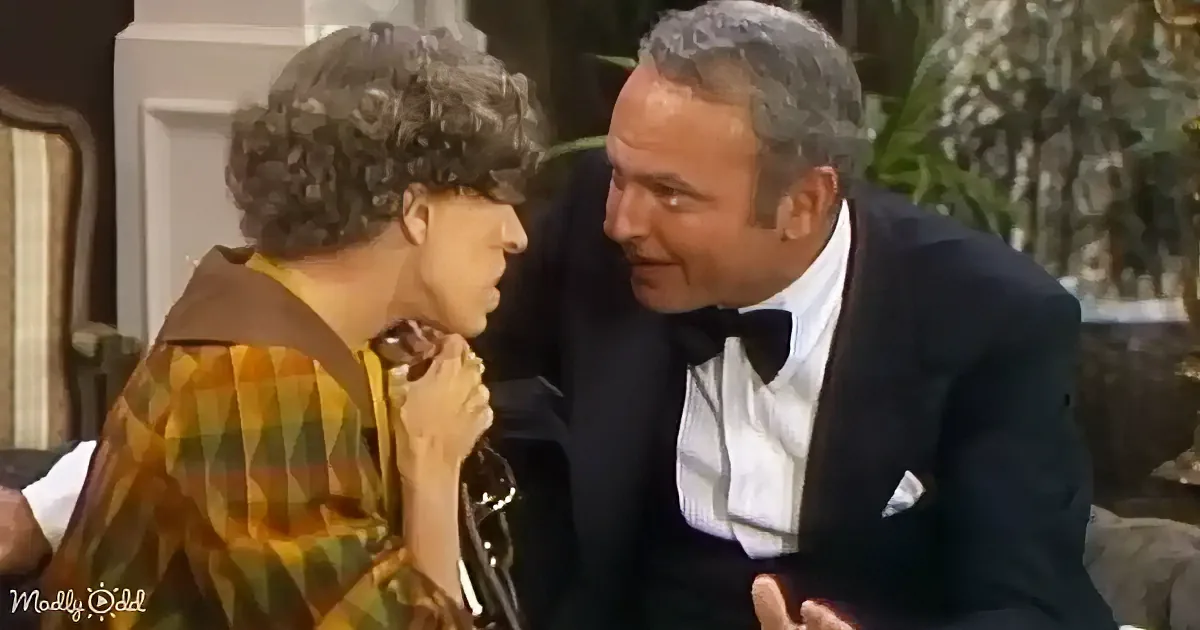 A man in a tuxedo leans close to a woman in a plaid shirt, both appearing engaged in a conversation.
