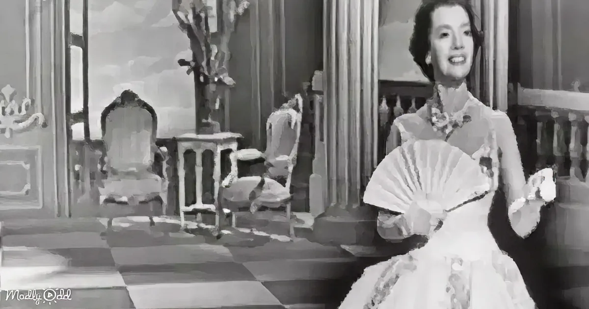 A woman in a vintage dress holds a fan, smiling, in a room with ornate furniture and checkered floor.