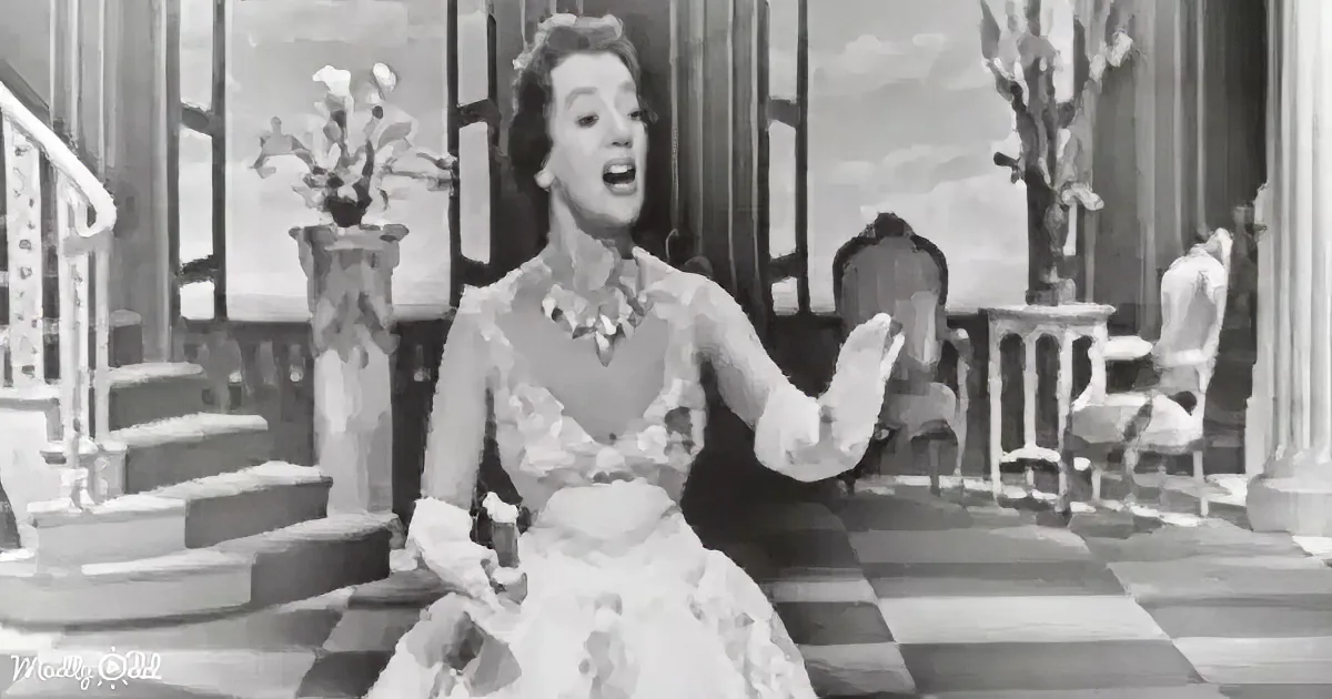 A woman in a floral dress laughs joyfully in a vintage setting with stairs and a vase of flowers.