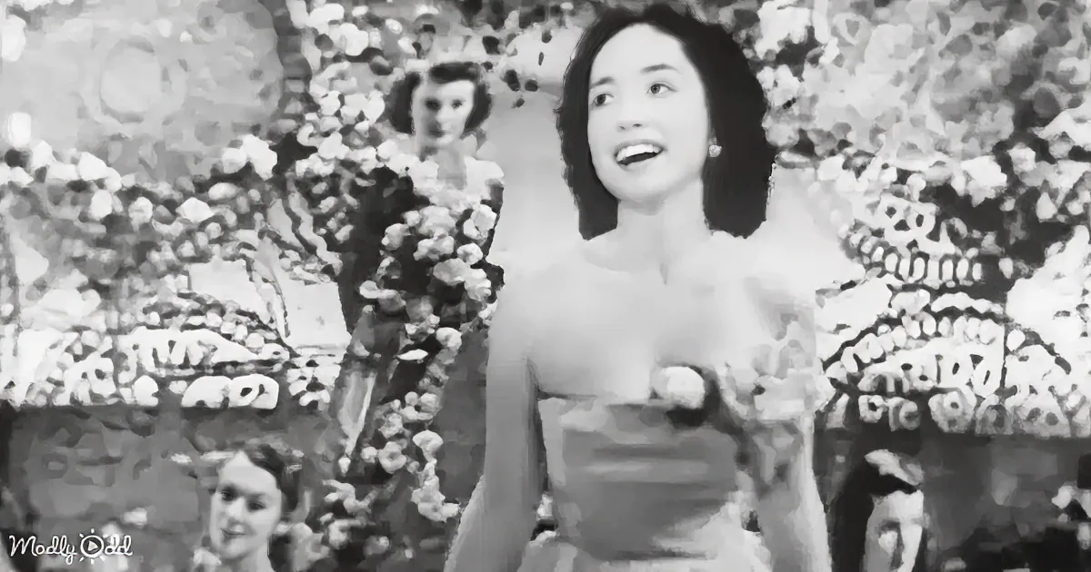 A woman with dark hair smiles, surrounded by floral elements in a black-and-white image.