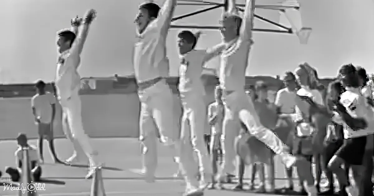 Cricket players celebrate a wicket with raised arms and joyous gestures.