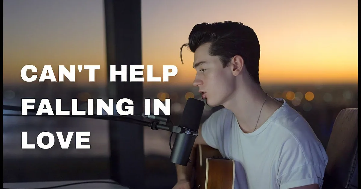 A person sings into a microphone while playing guitar, set against a sunset cityscape.