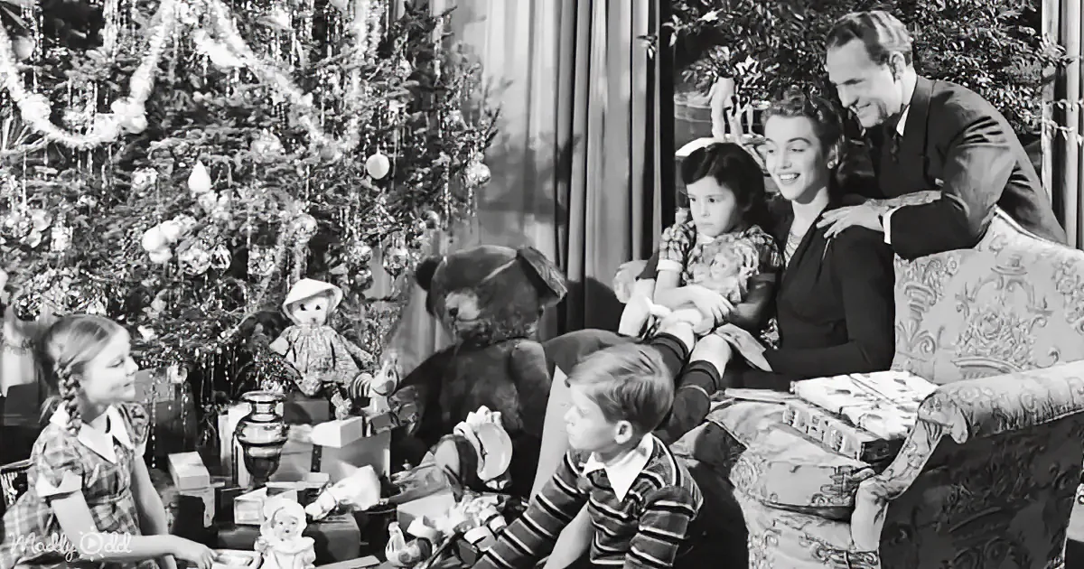 A family celebrates Christmas with gifts, decorations, and a large teddy bear.