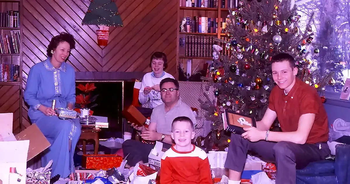 A family gathers around a Christmas tree with presents and decorations, smiling and enjoying the holiday season.