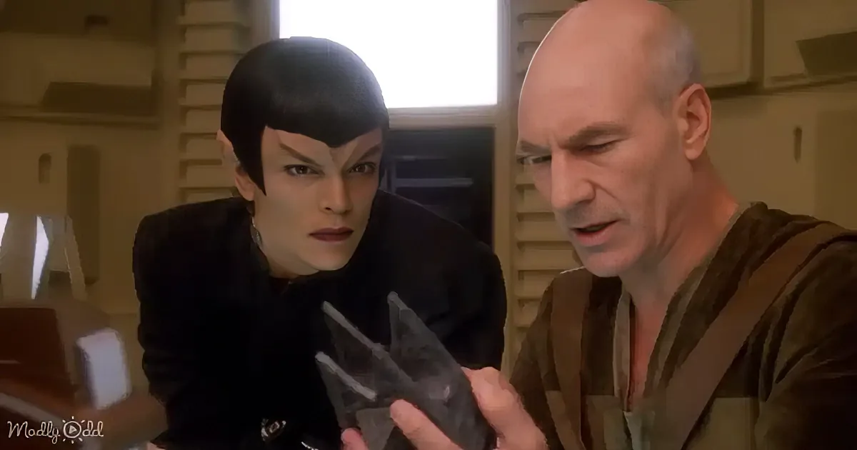 A person in a Star Trek uniform holds a small object while another person in a brown shirt looks on.