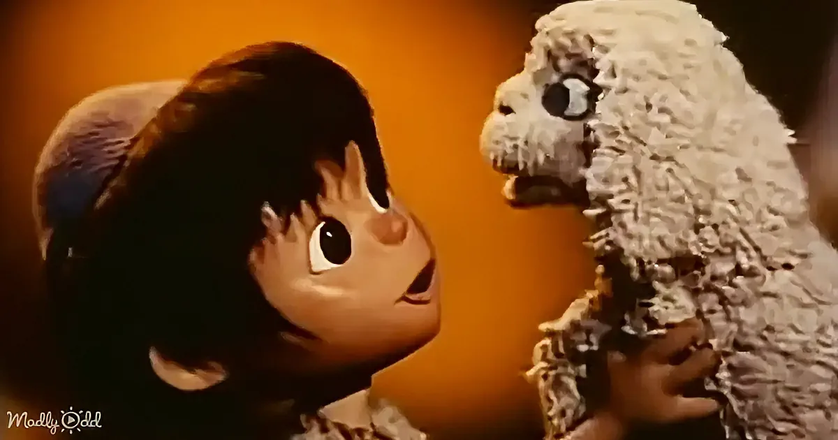 A puppet character with a fluffy white head and a child with braided hair are facing each other against an orange background.