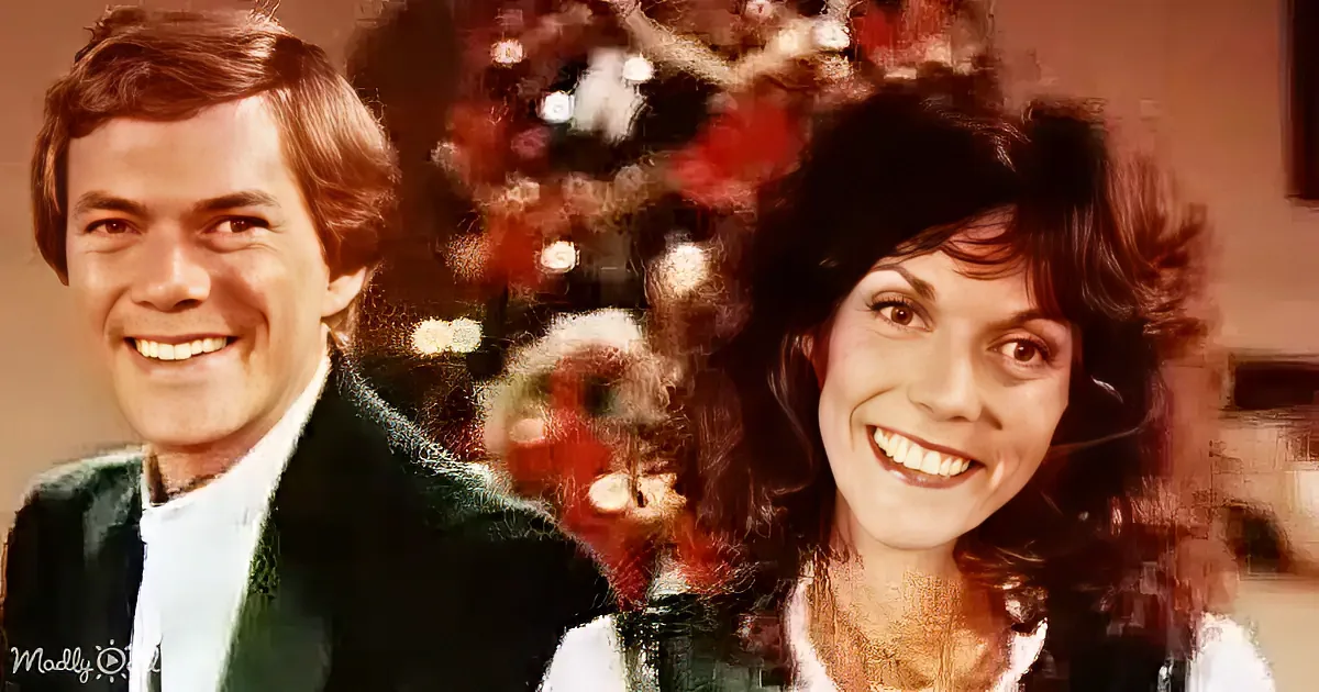 A smiling couple stands in front of a decorated Christmas tree, both wearing festive attire.