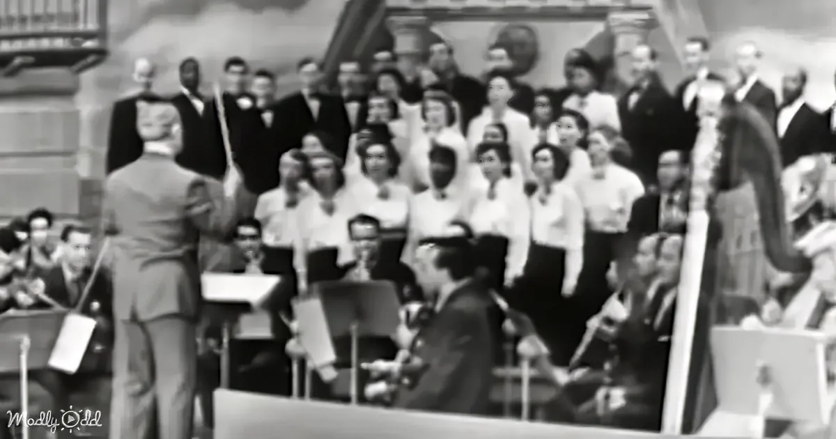 Conductor leads orchestra with sheet music, surrounded by musicians and choir in formal attire.