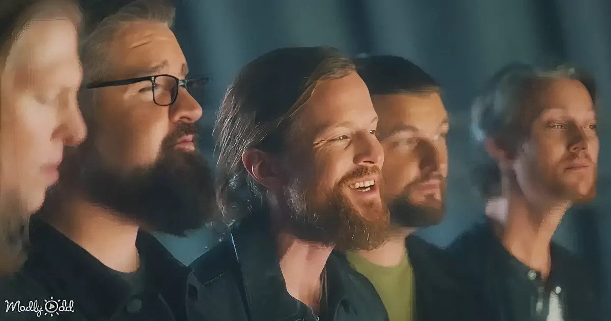 A group of men with beards and long hair, singing or speaking in unison.