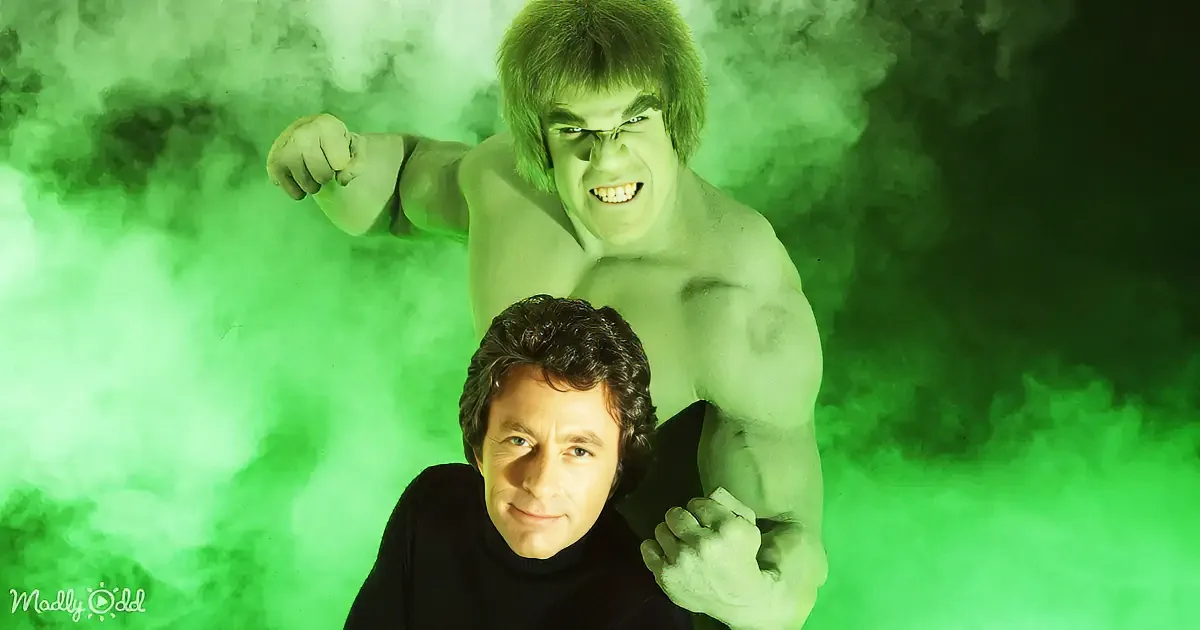 A man in a black shirt sits in front of a green Hulk figure with a green smoke background.