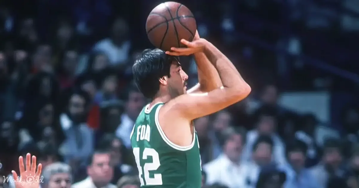 A basketball player in a green jersey with the number 12 prepares to shoot the ball during a game.