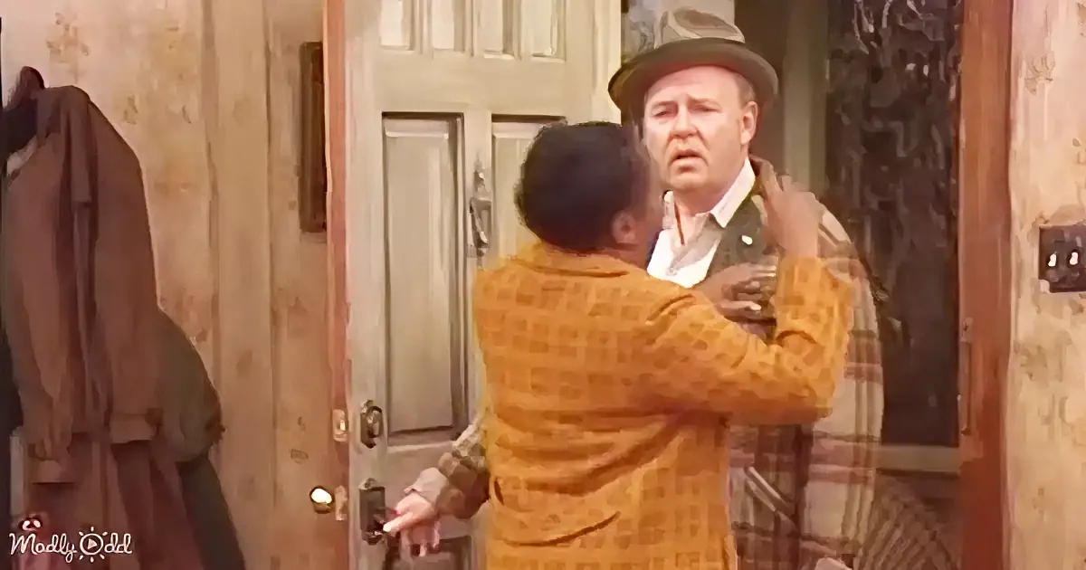 A man in a yellow checkered suit is holding another man in a plaid shirt by the shoulders, both appearing to be in a...