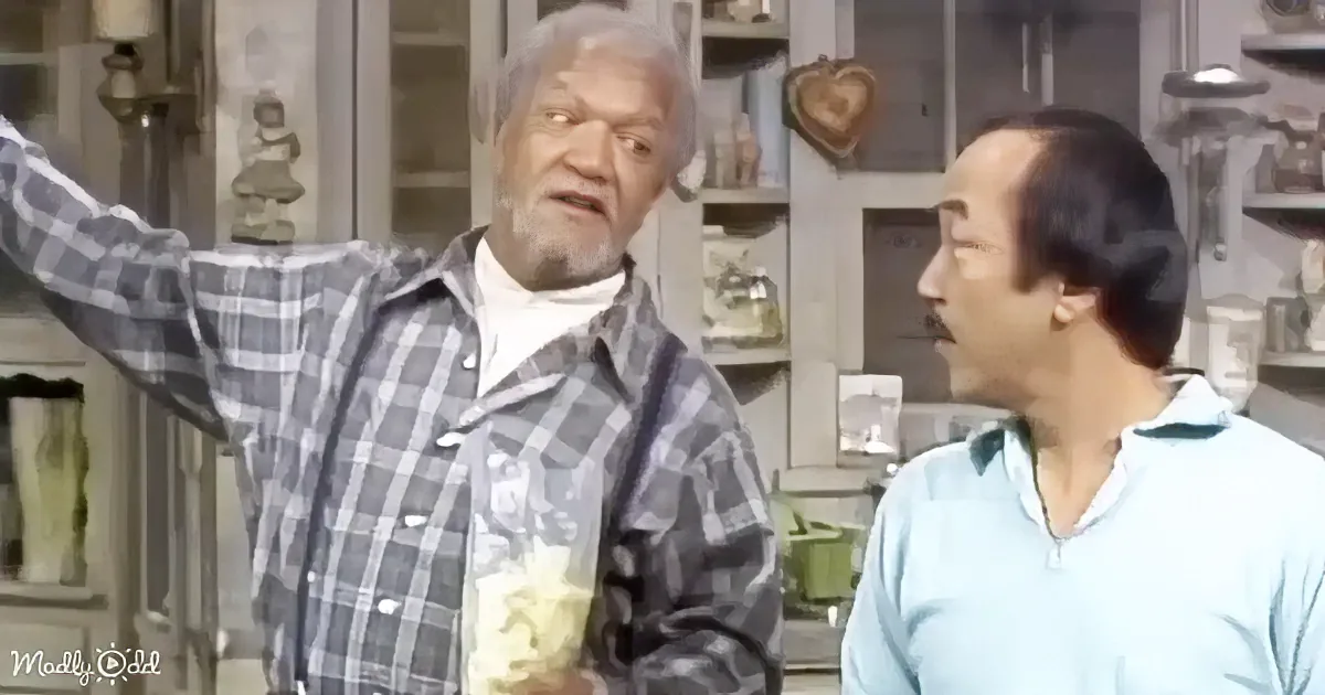 An older man in a plaid shirt gestures dramatically while holding popcorn, standing next to another man in a light blue...