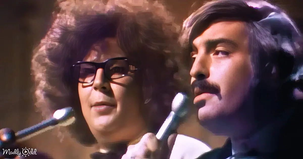 Two individuals with curly hair, one holding a microphone, performing or singing.