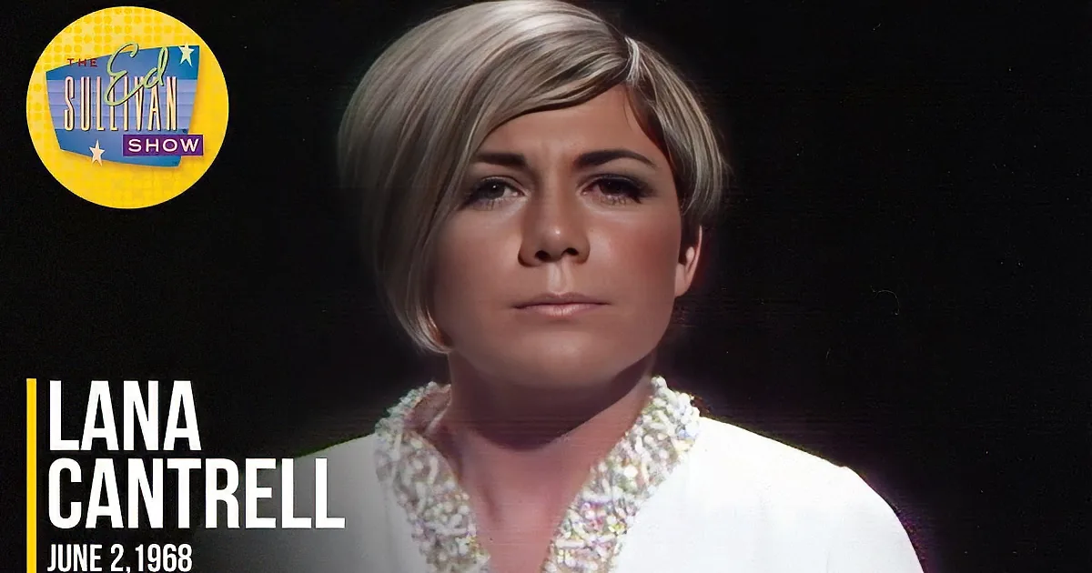 A person with short, styled hair and a white, beaded top is featured against a dark background.
