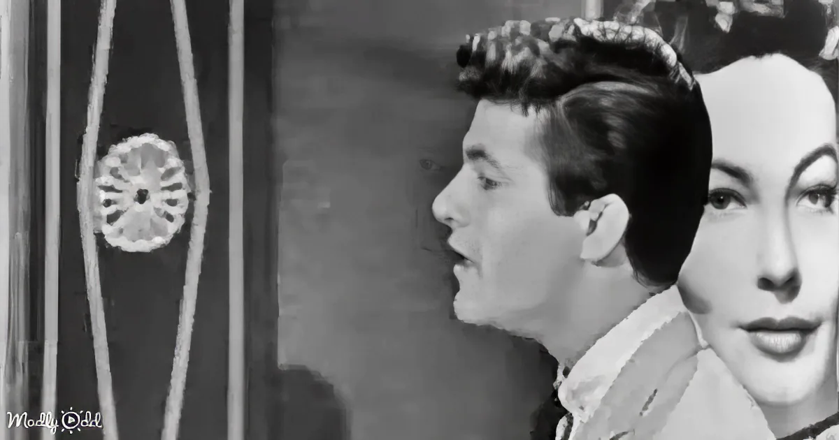 A man with a quiff hairstyle and a woman with a vintage hairstyle are shown in profile, possibly in a scene from a...