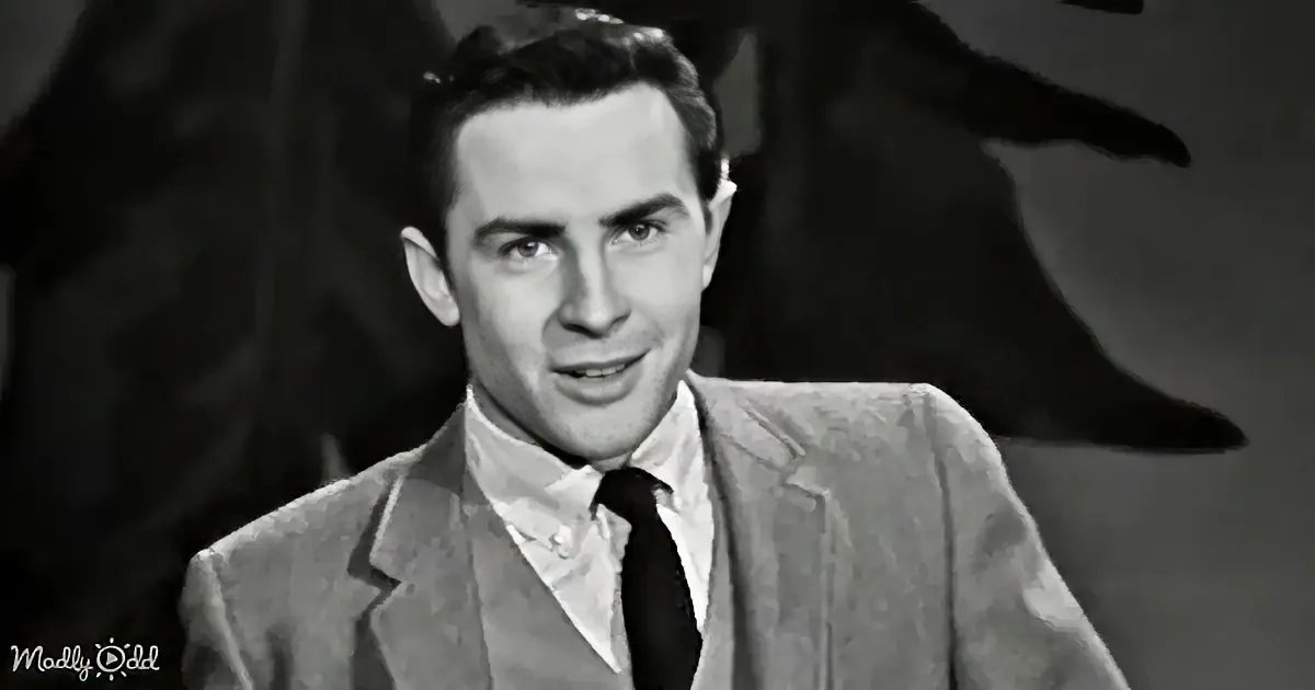 A man in a suit and tie, smiling, with a dark background.