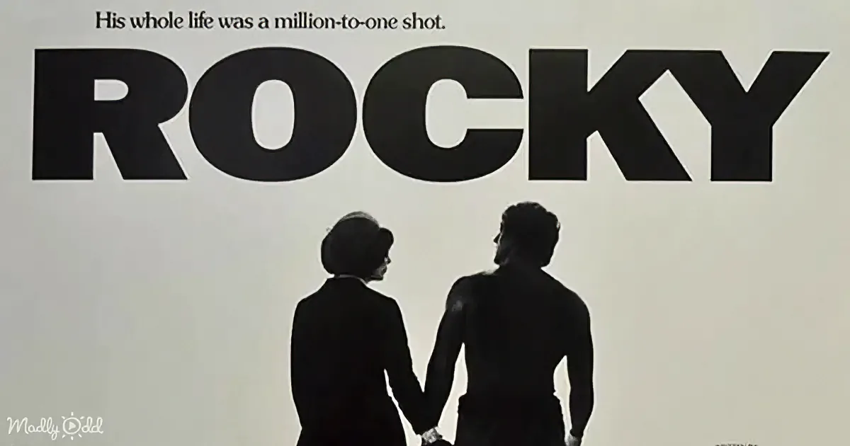 Two silhouetted figures holding hands, one in formal attire, the other shirtless, against a minimalist background.