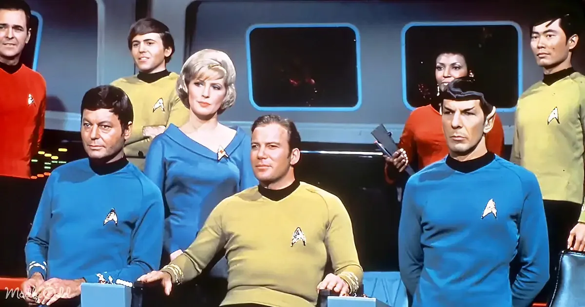 Captain Kirk sits at a console with his crew in their distinctive uniforms, ready for action.