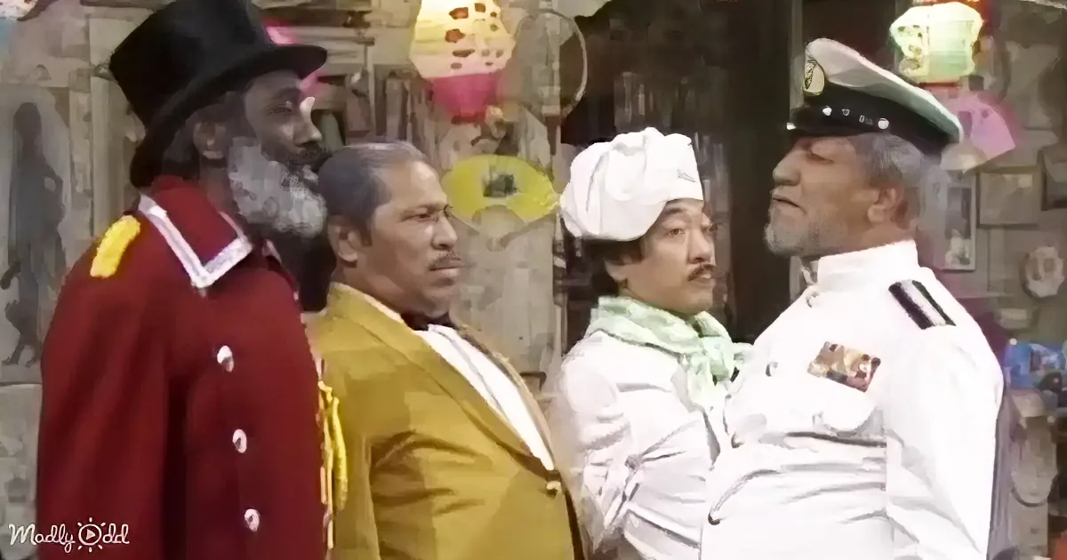 A man in a red uniform with a top hat stands beside another in a yellow suit, both facing a man in a white uniform with a...