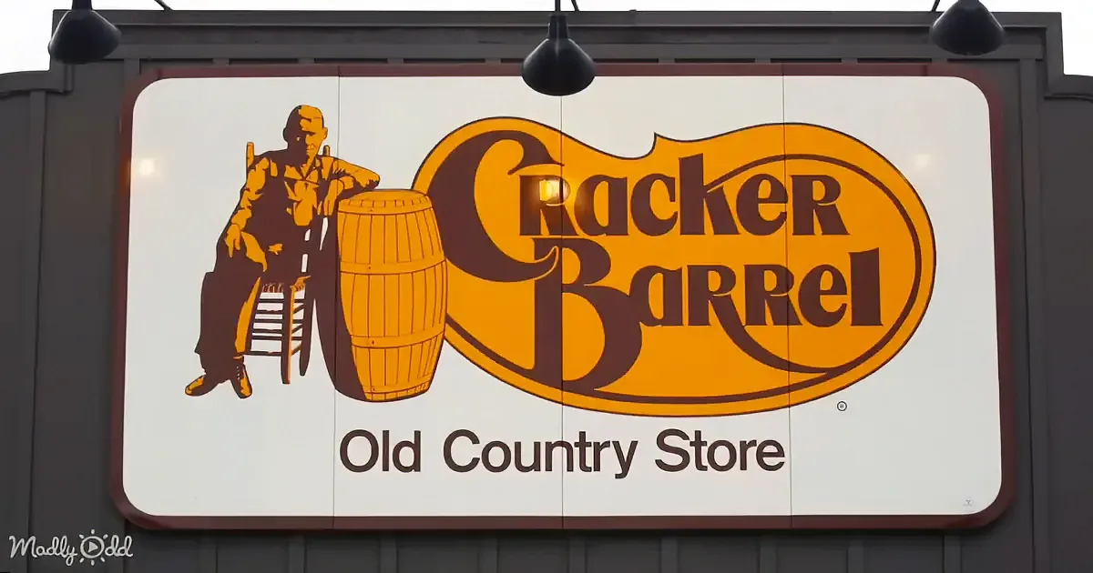 A Cracker Barrel Old Country Store sign with a man sitting on a stool next to a barrel.