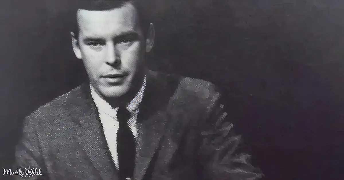 A man in a suit and tie, seated, facing slightly to the left, in a black-and-white photograph.