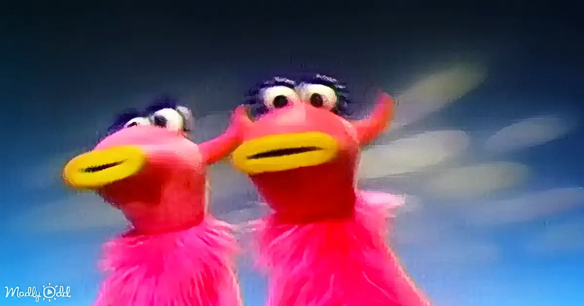 Two pink Elmo-like characters with yellow mouths and black eyebrows, standing close together against a blue background.