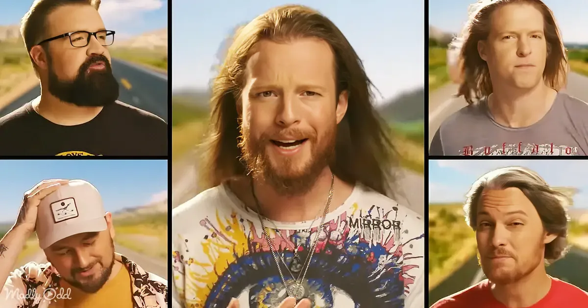 A man with long hair and a beard stands outdoors, surrounded by other individuals in various poses and outfits.