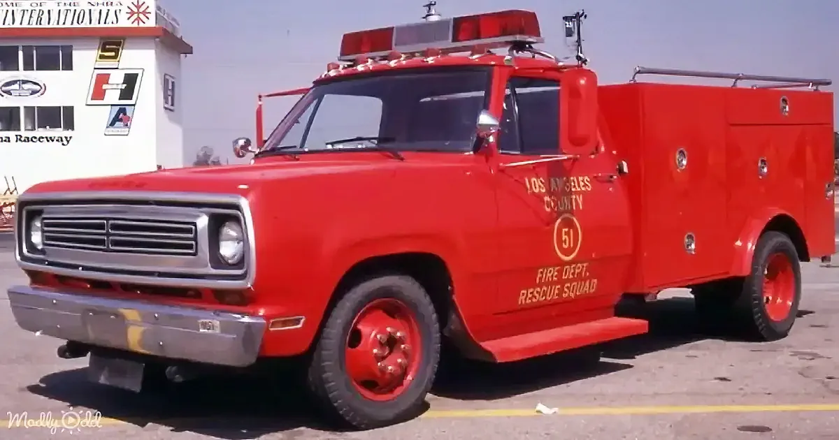 A red Los Angeles County Fire Dept. Rescue Squad truck with "51" on it is parked in front of a building.