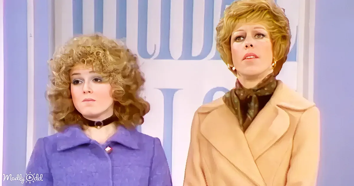 Two women in vintage attire stand side by side, one in a blue coat, the other in a beige coat, against a striped backdrop.