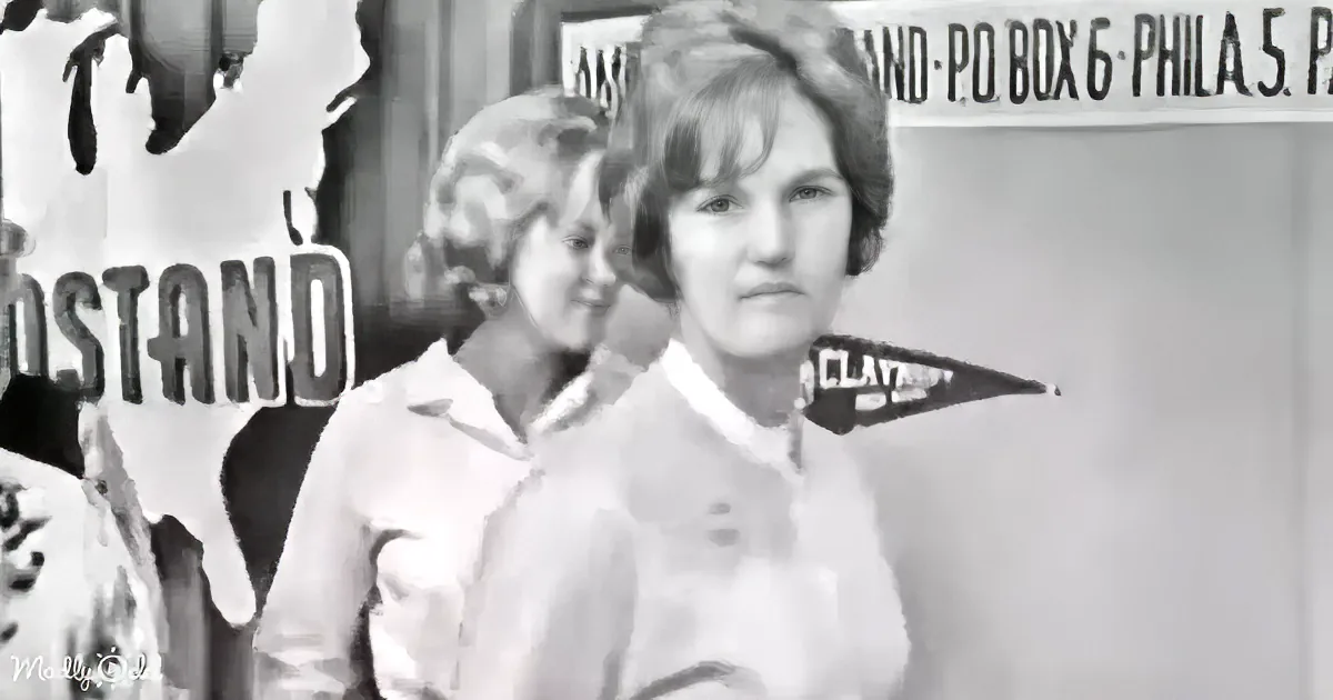 A woman in a white shirt stands in front of a sign with "CLAY" and "PHILA 5" visible.
