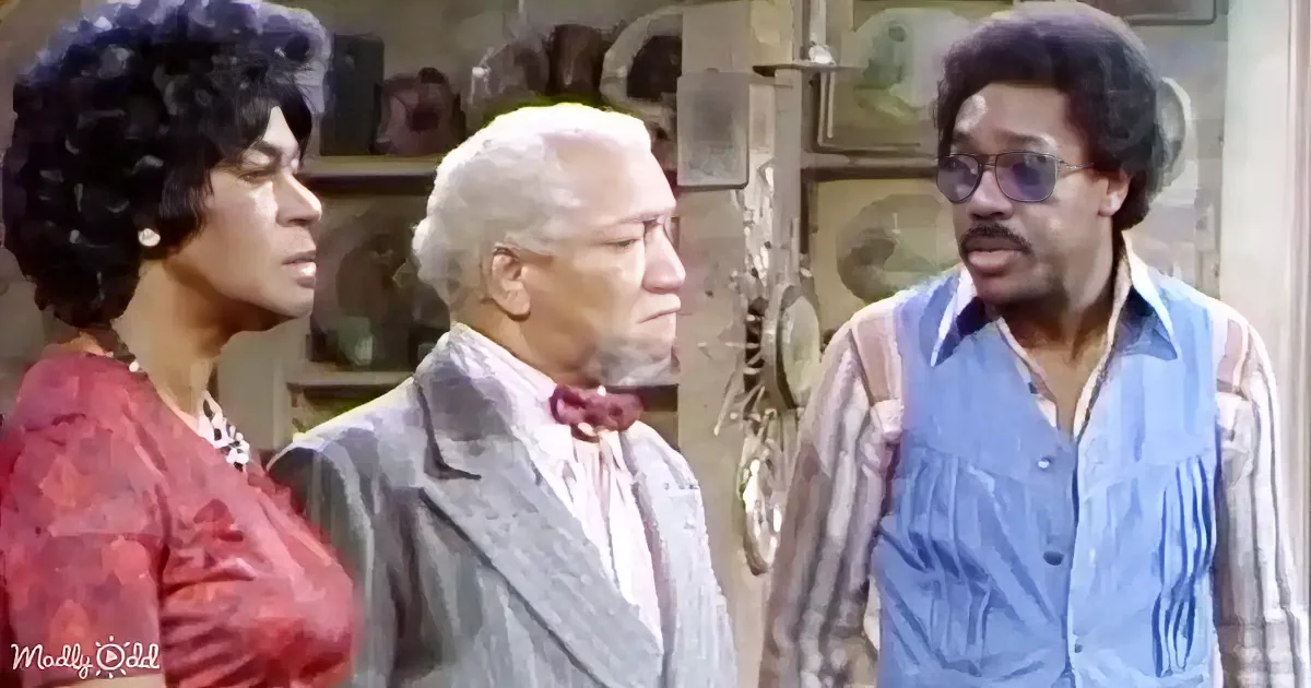 A man in a suit and bow tie stands between two others, one in a red dress and the other in a blue shirt, in a room with...