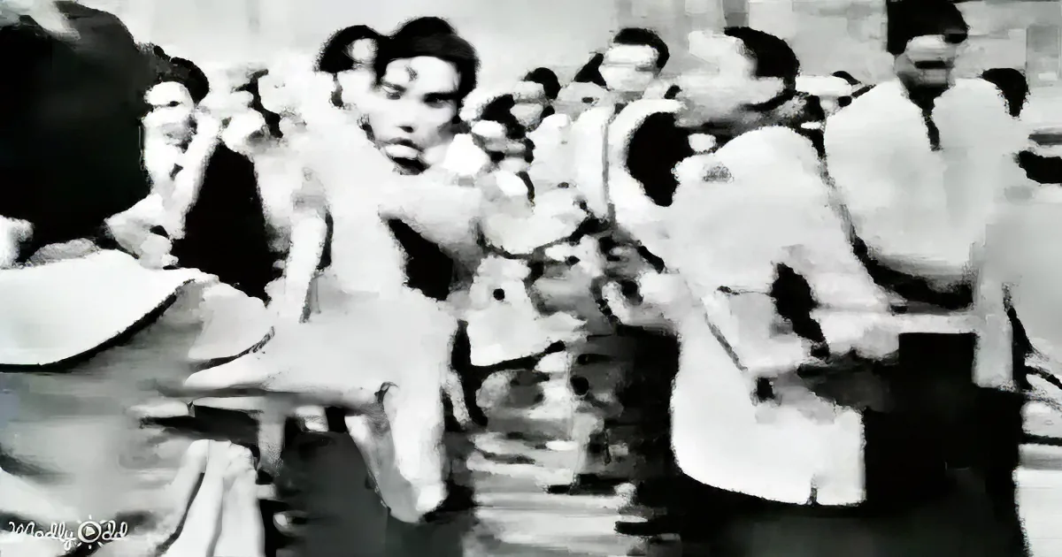 A man in a light-colored shirt is being held by several others, appearing to be in a crowd or public setting.