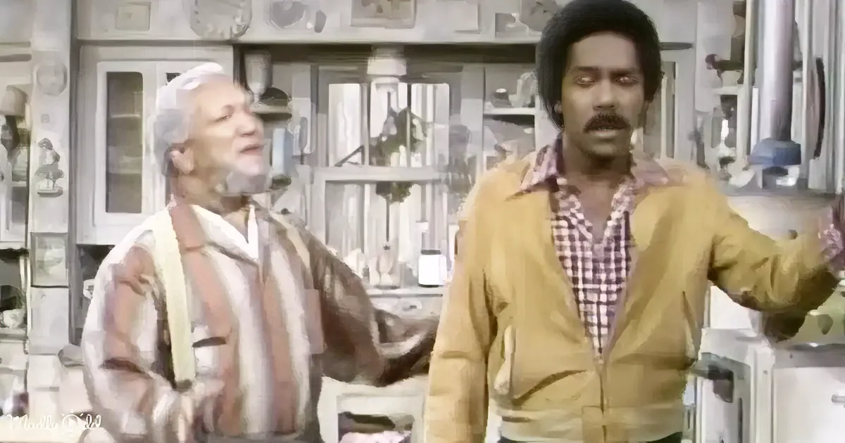 A man in a yellow jacket gestures emphatically while another man in a striped shirt looks up, both in a kitchen setting.