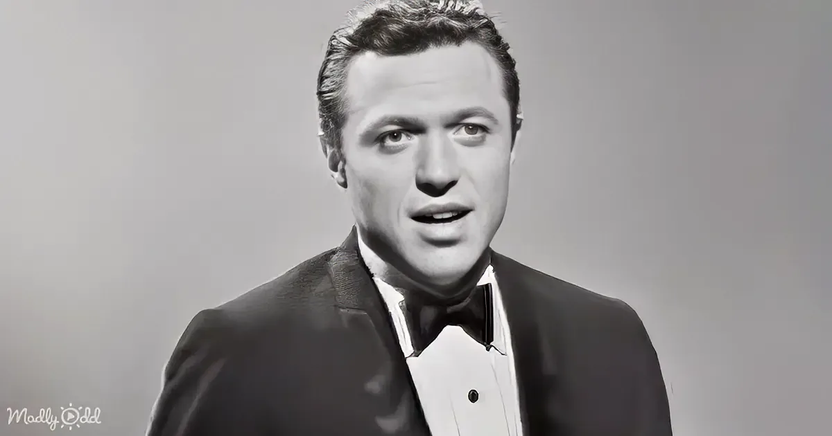 A man in a suit and bow tie, looking slightly to the side with a serious expression.