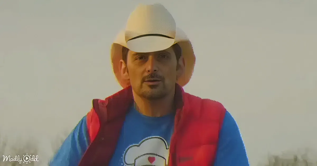 A man wearing a white cap, red and blue jacket, and a blue shirt with a chef's hat graphic stands outdoors.