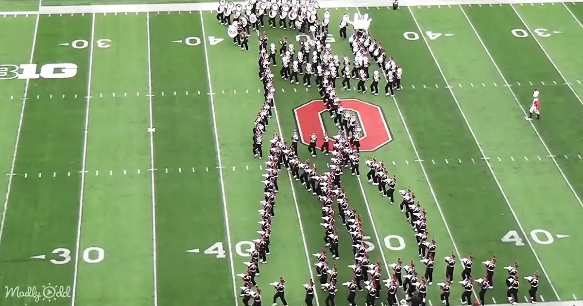 A marching band forms a large "7" on a football field with the Ohio State Buckeyes logo nearby.